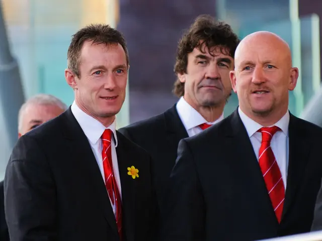 In the foreground of this image, there are four men standing in suits and in the background image...