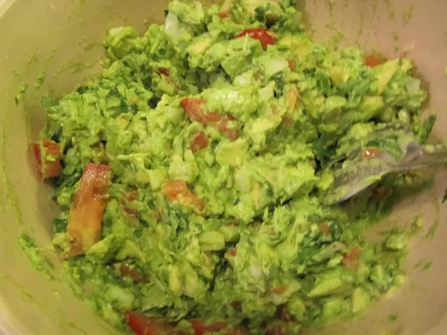 In this image we can see the preparation of food item with a spoon in the bowl.