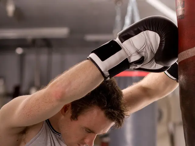 In this image there is one person who is wearing gloves, and in front of him there is a boxing...
