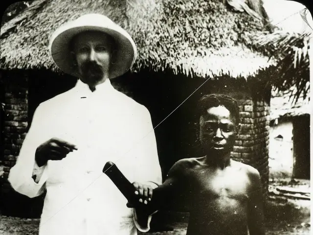 In this picture we can see two men, the left side man wore a cap, behind to them we can see few...