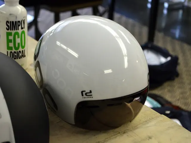 In this image we can see a helmet and a bottle placed on the table.