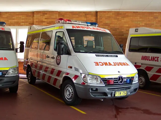 In the middle it is an ambulance which is in white color behind it. There is a brick wall.